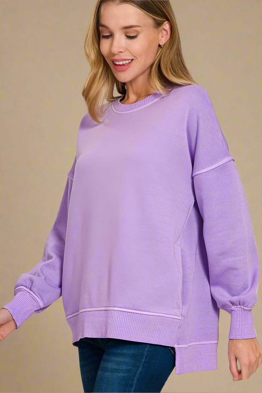 Woman wearing a lavender sweatshirt on a beige background