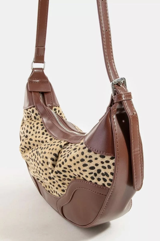 Leopard print handbag with brown leather accents on a white background