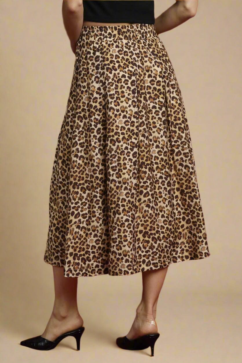 Leopard print skirt worn by a person on a beige background
