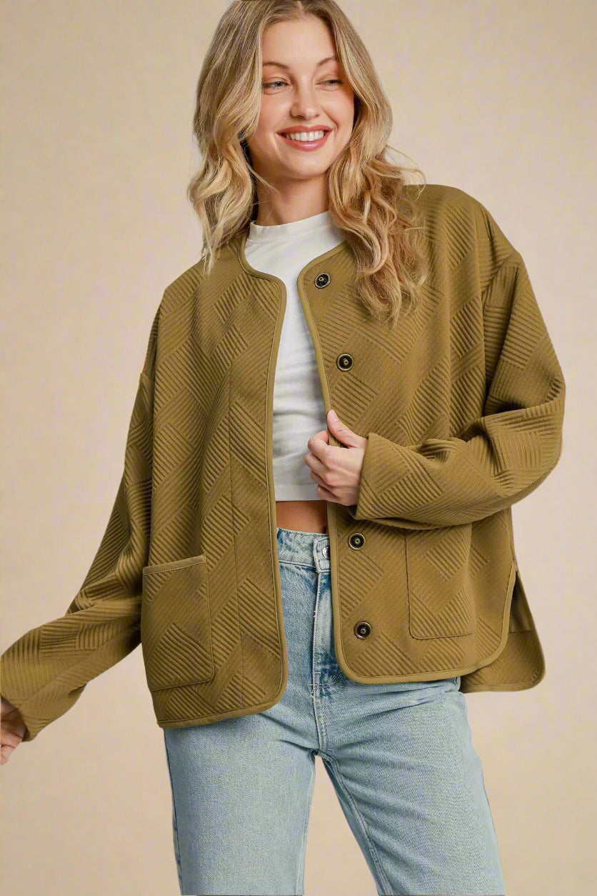 Woman wearing a camel jacket with a plain background