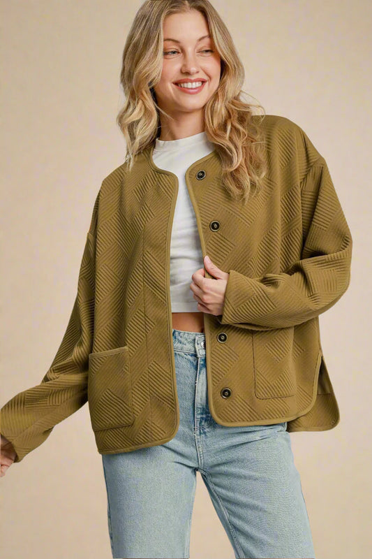 Woman wearing a camel jacket with a plain background