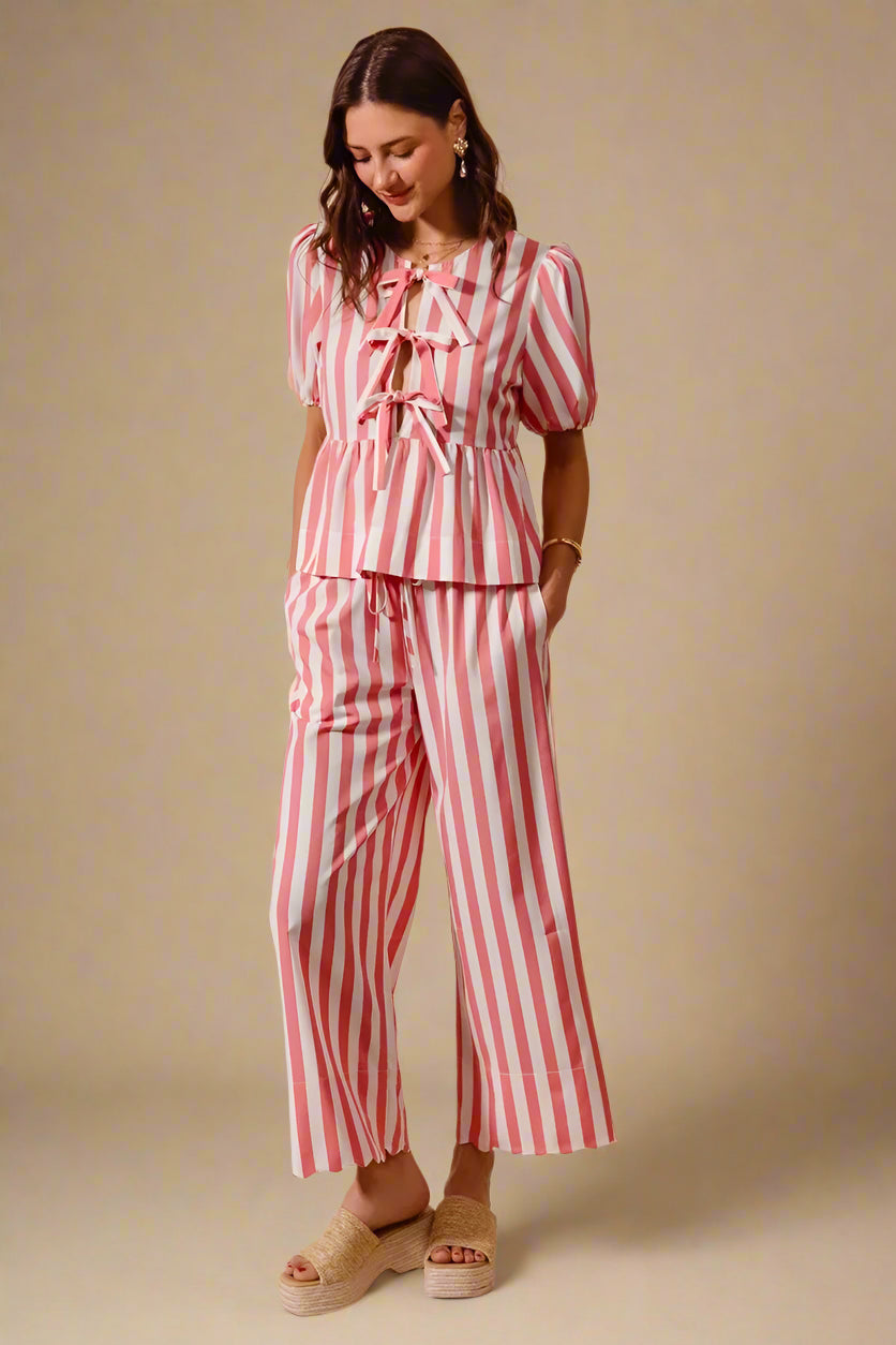 Woman wearing a red and white striped outfit on a beige background