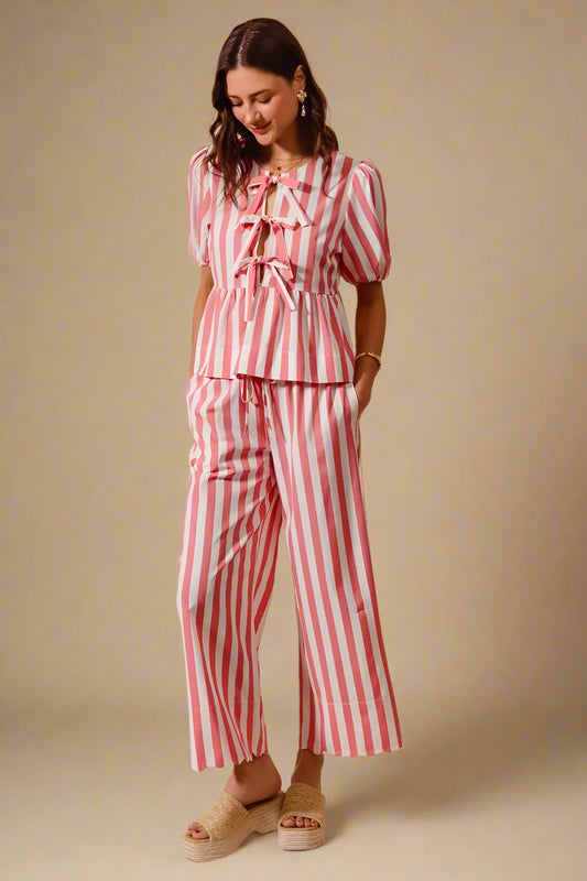 Woman wearing a red and white striped outfit on a beige background