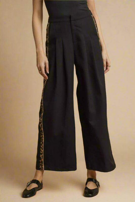 Black wide-leg pants with side stripes on a brown background