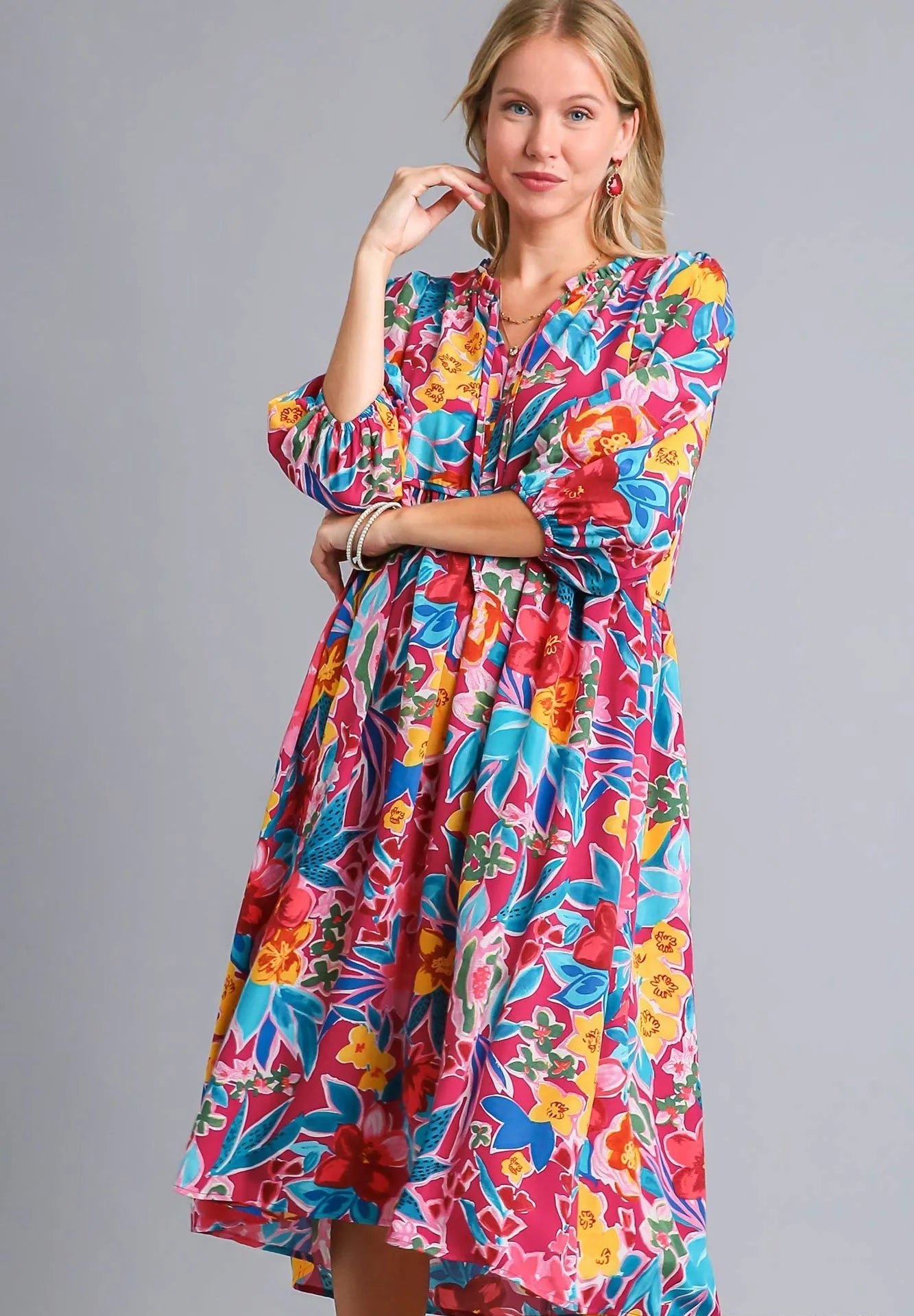 Woman wearing a colorful floral dress on a gray background