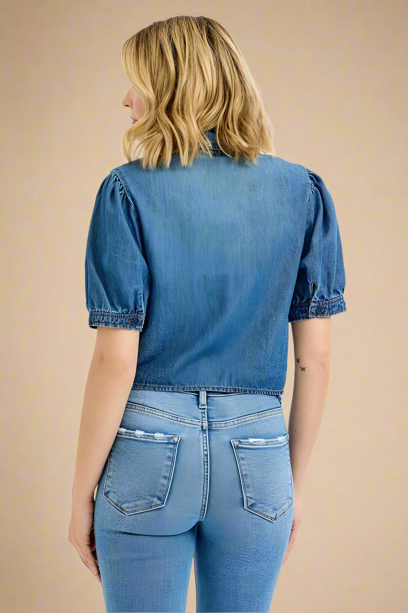 Person wearing a blue denim shirt and jeans on a white background