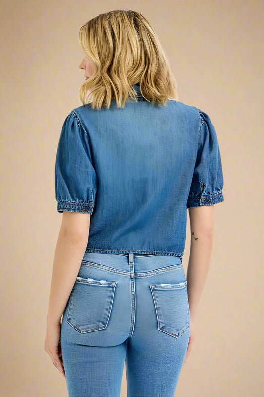 Person wearing a blue denim shirt and jeans on a white background