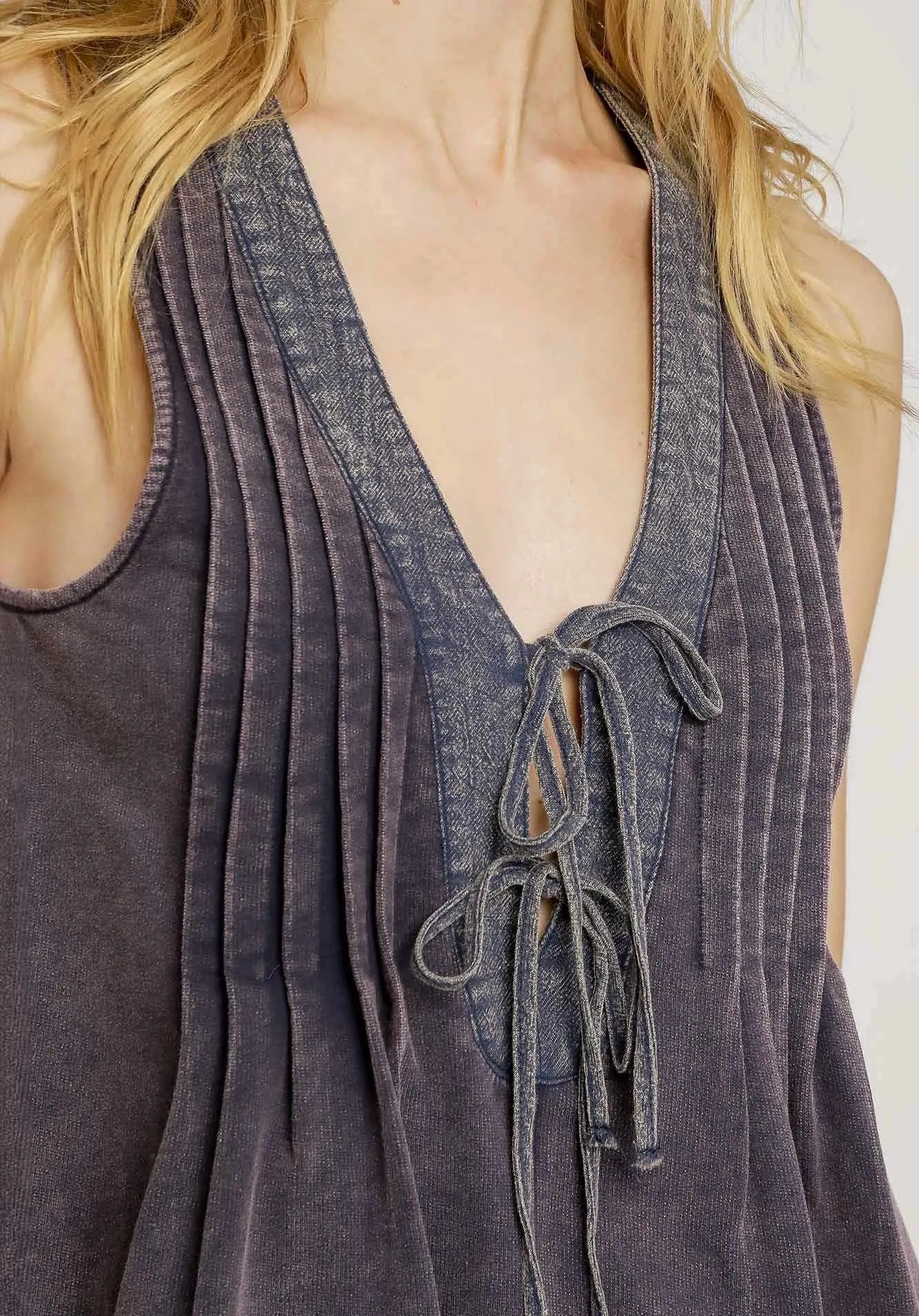Navy sleeveless top with lace-up detail on a blurred background