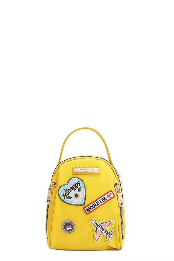 Yellow backpack with various patches on a white background