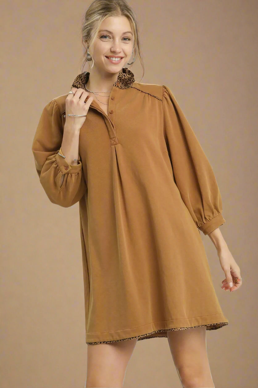 Woman wearing a brown dress with a plain background