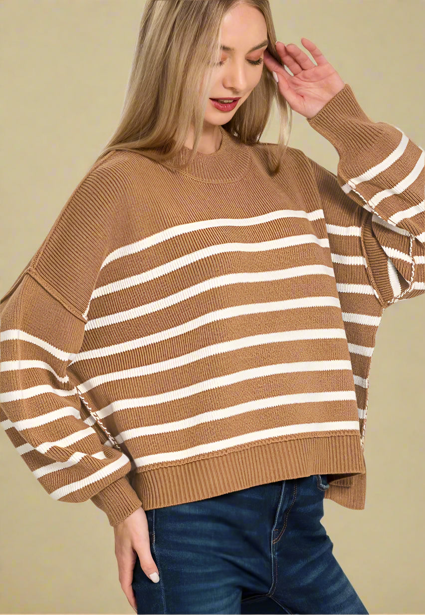 Woman wearing a brown and white striped sweater on a white background