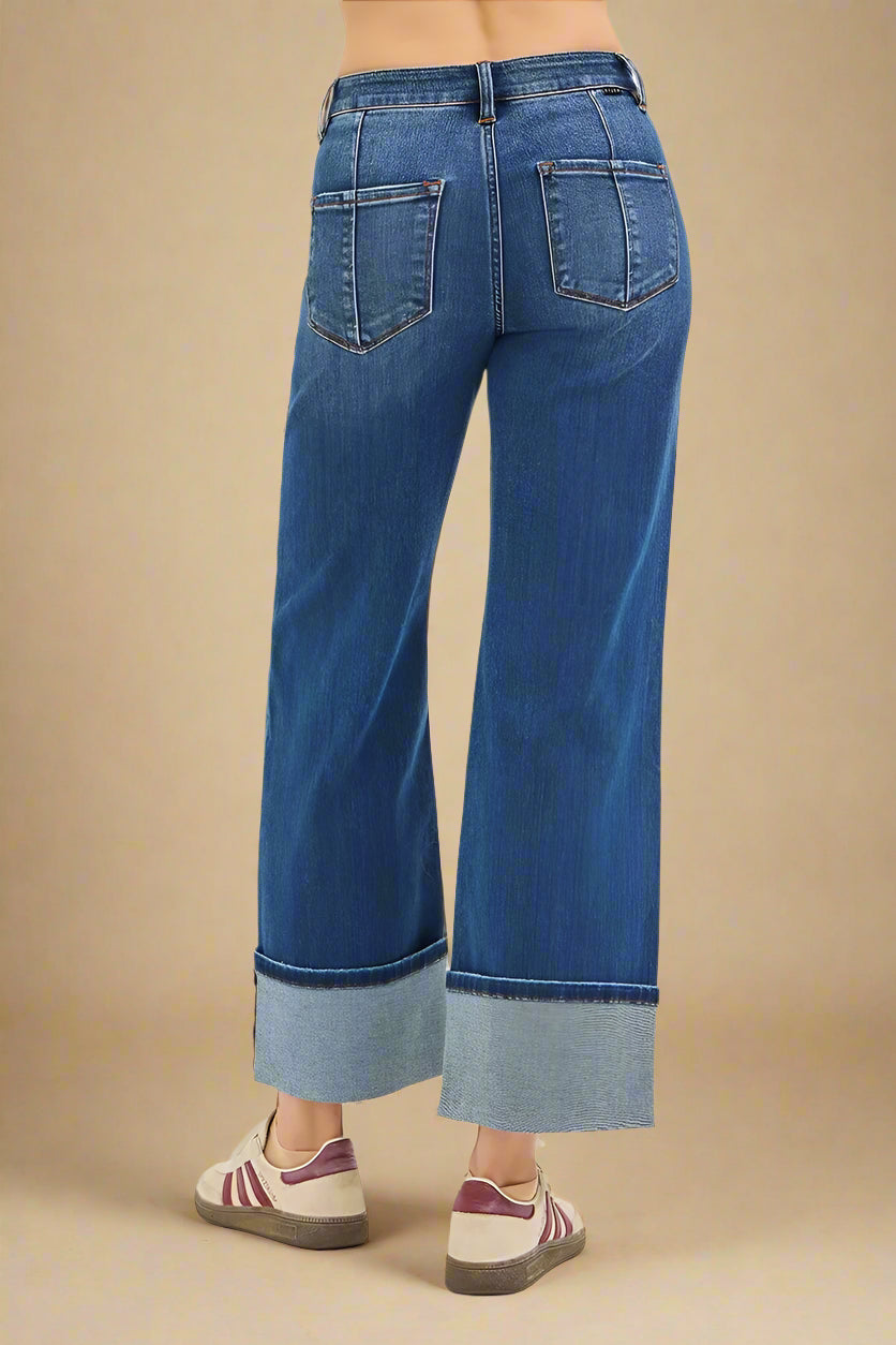 Blue jeans with cuffed hems on a white background
