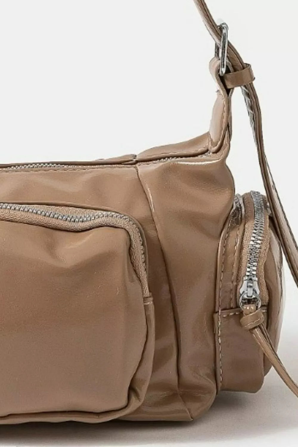 Brown leather handbag with a shoulder strap on a light gray background