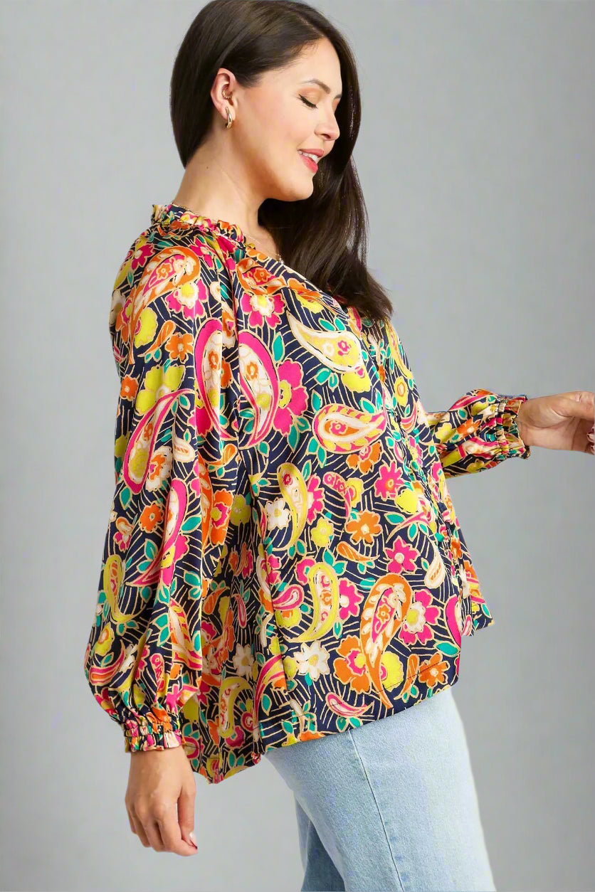 Woman wearing a colorful paisley blouse on a white background