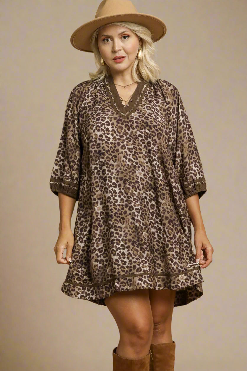 Woman wearing a leopard print dress with a beige hat on a beige background