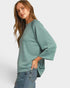 Woman wearing a light green sweater with a plain background