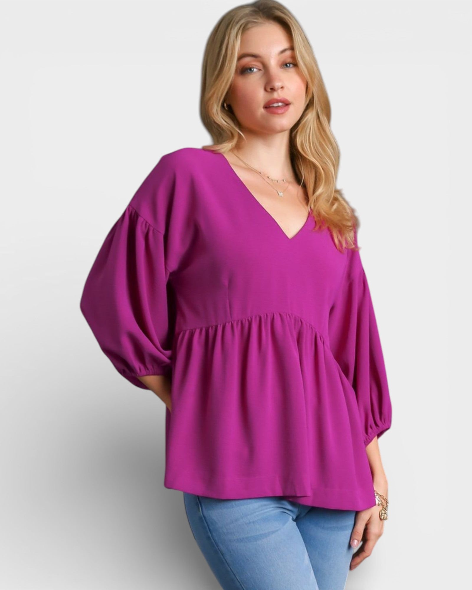 Woman wearing a purple blouse with balloon sleeves on a white background