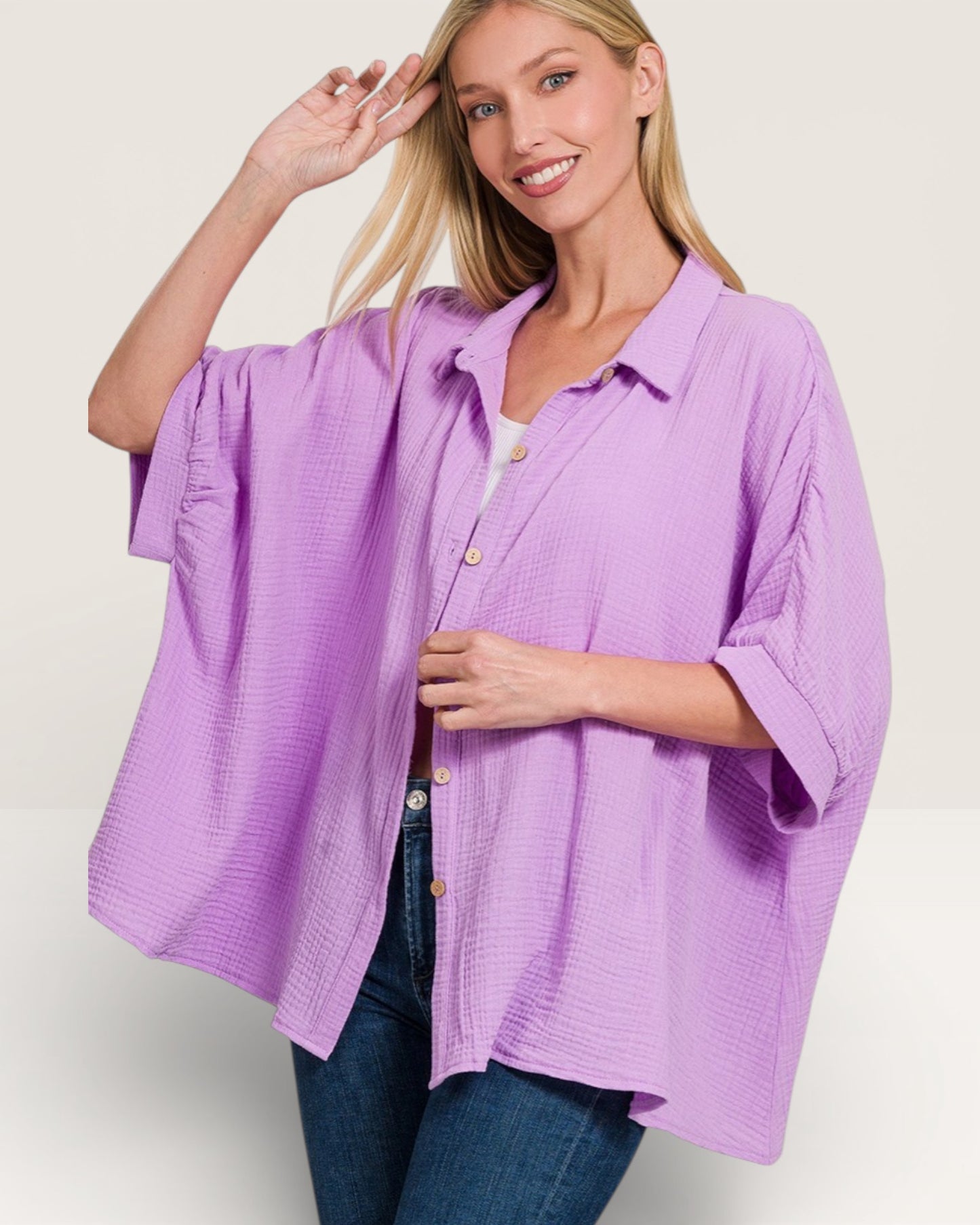 Woman wearing a purple shirt with rolled-up sleeves on a plain background