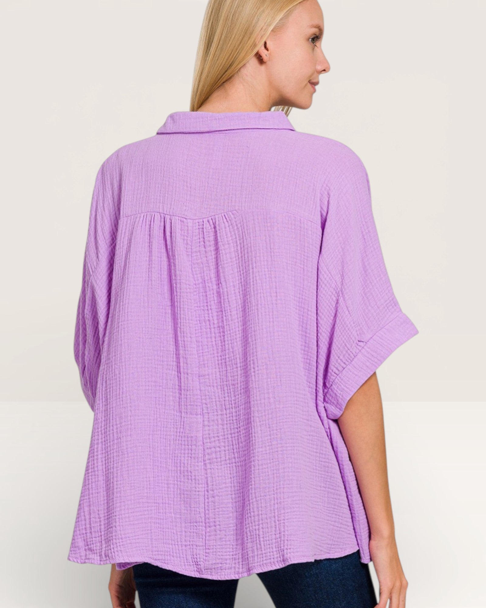 Woman wearing a purple textured blouse against a plain background