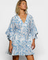 Woman wearing a blue and white patterned dress on a plain background