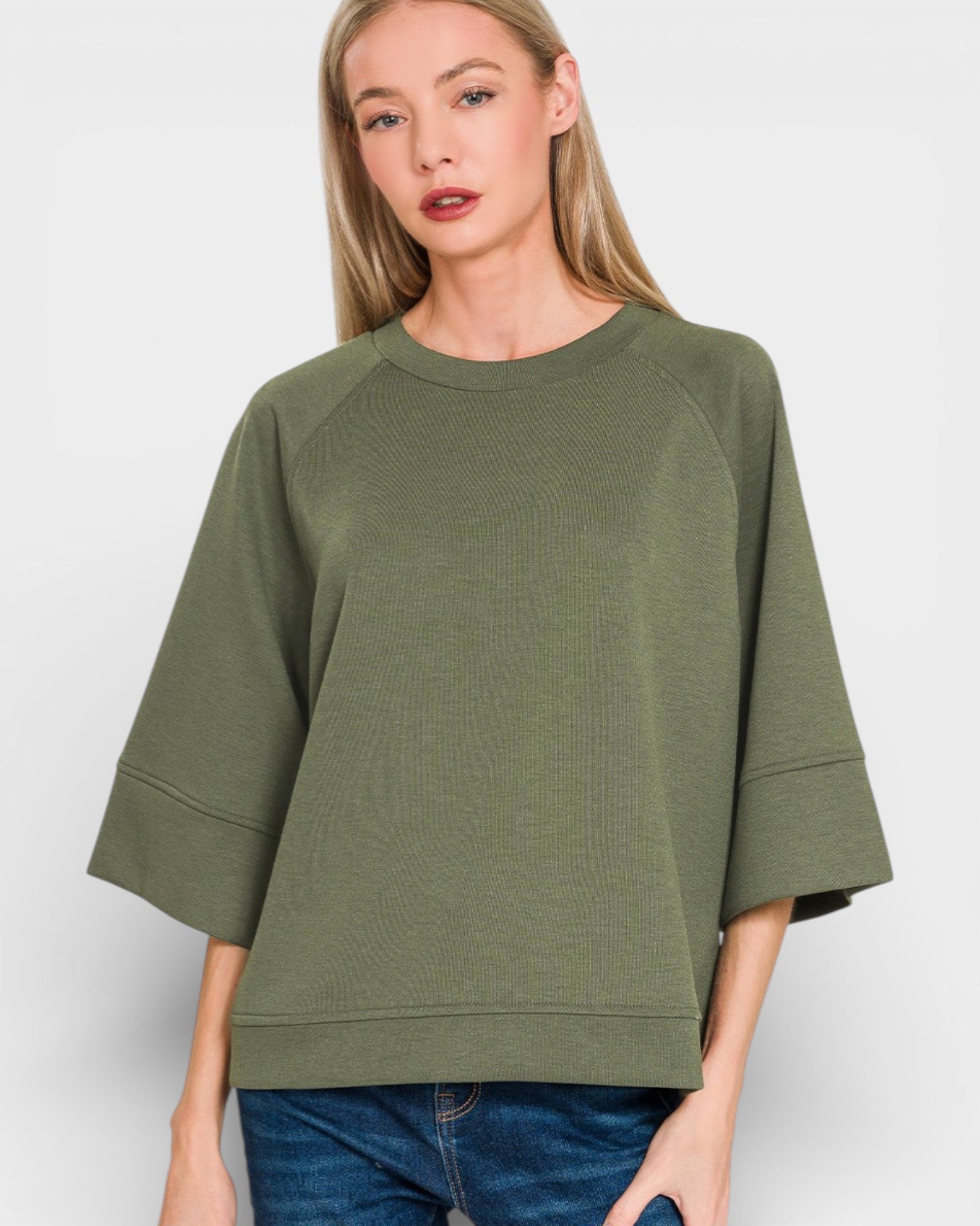 Woman wearing an olive green oversized sweater on a white background