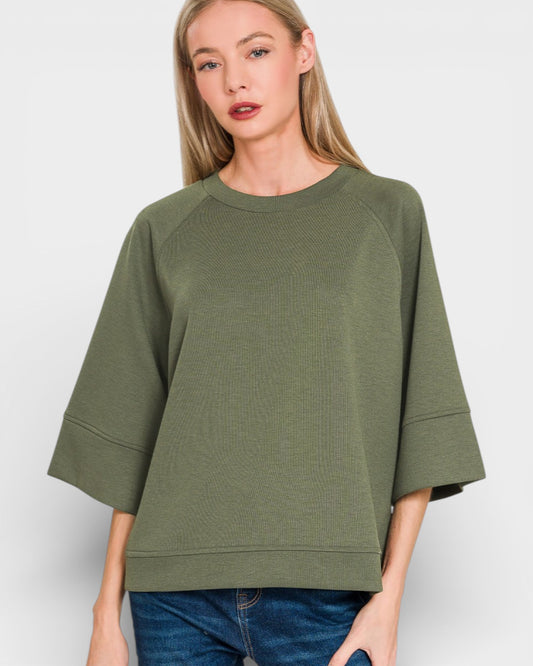 Woman wearing an olive green oversized sweater on a white background