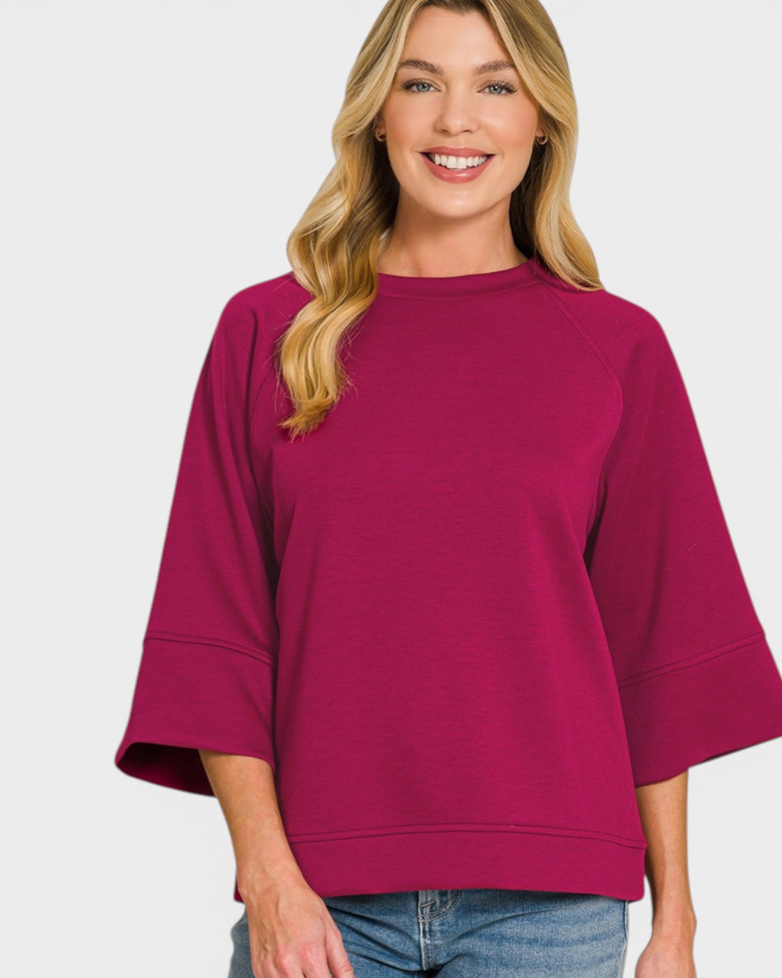 Woman wearing a magenta sweater on a white background