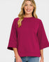 Woman wearing a magenta sweater on a white background