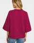 Person wearing a magenta sweater on a plain background