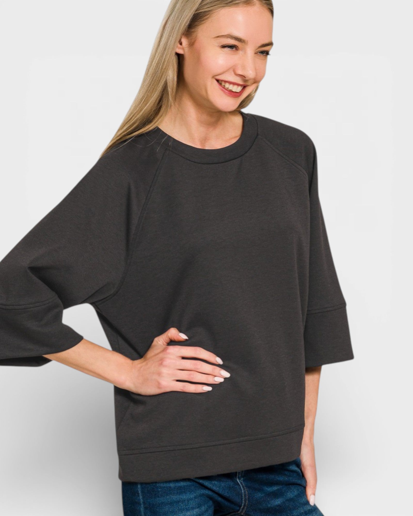 Woman wearing a black oversized sweatshirt against a white background