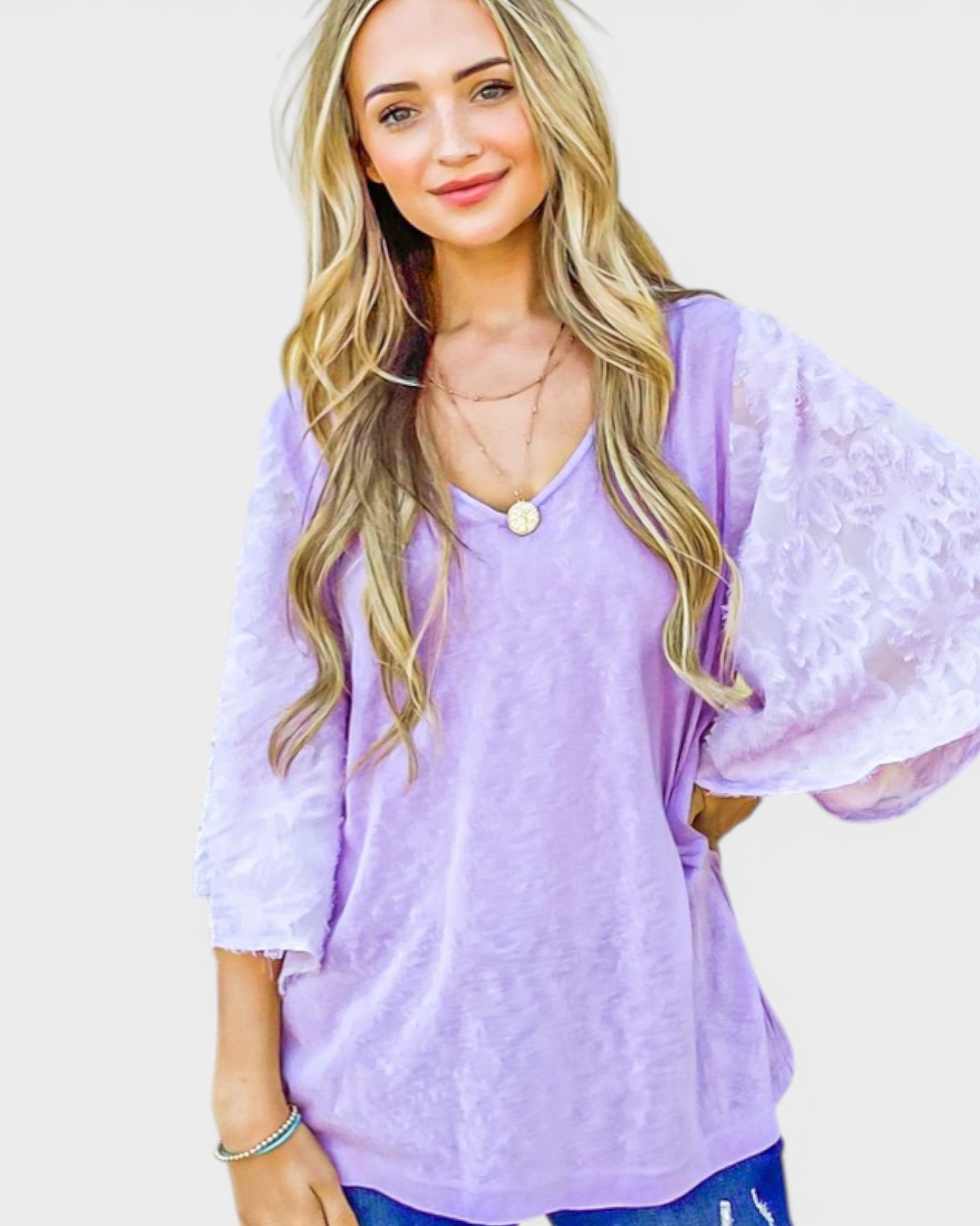 Woman wearing a light purple blouse with a plain background