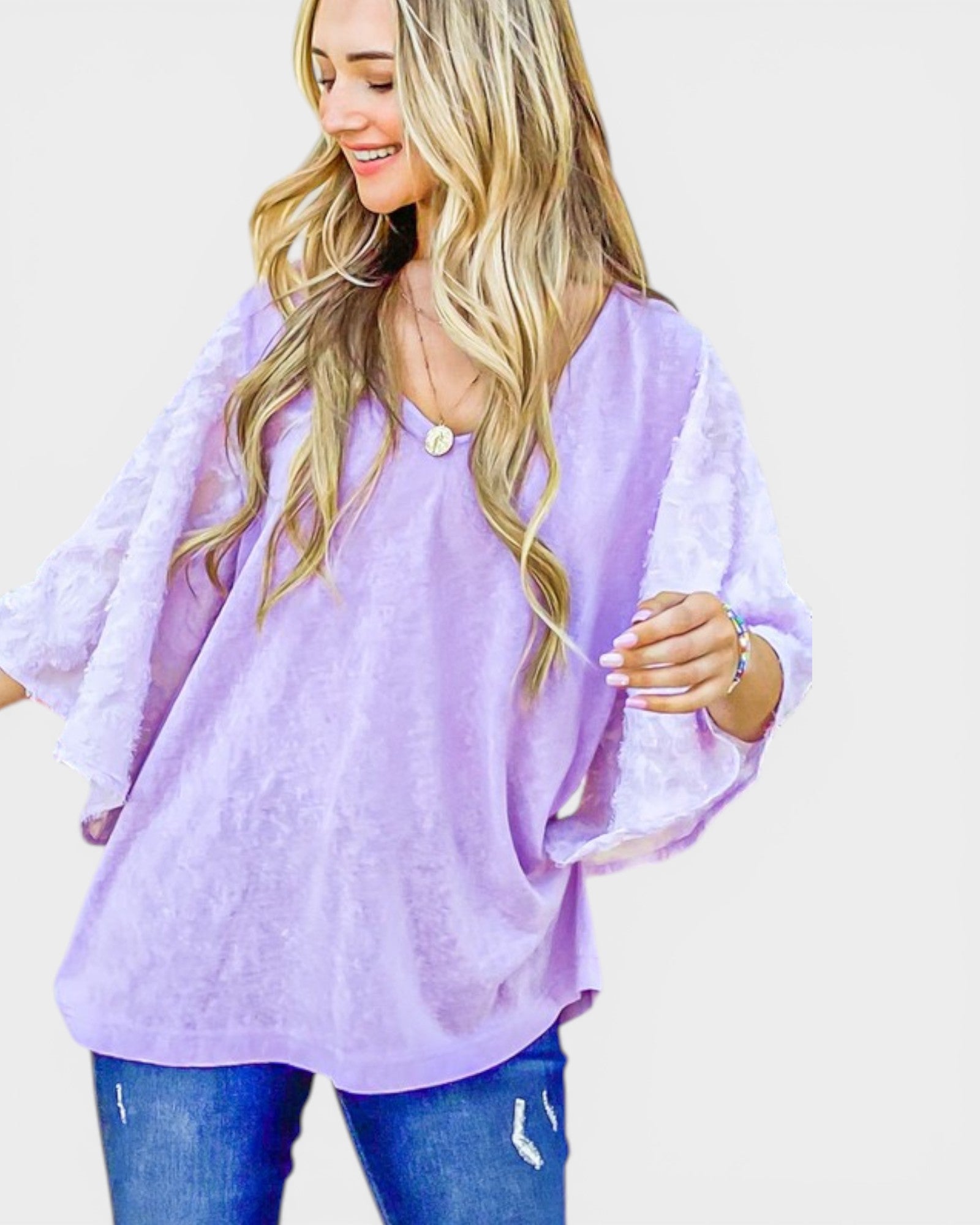 Woman wearing a light purple blouse with a plain background