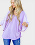 Woman wearing a light purple blouse with a plain background
