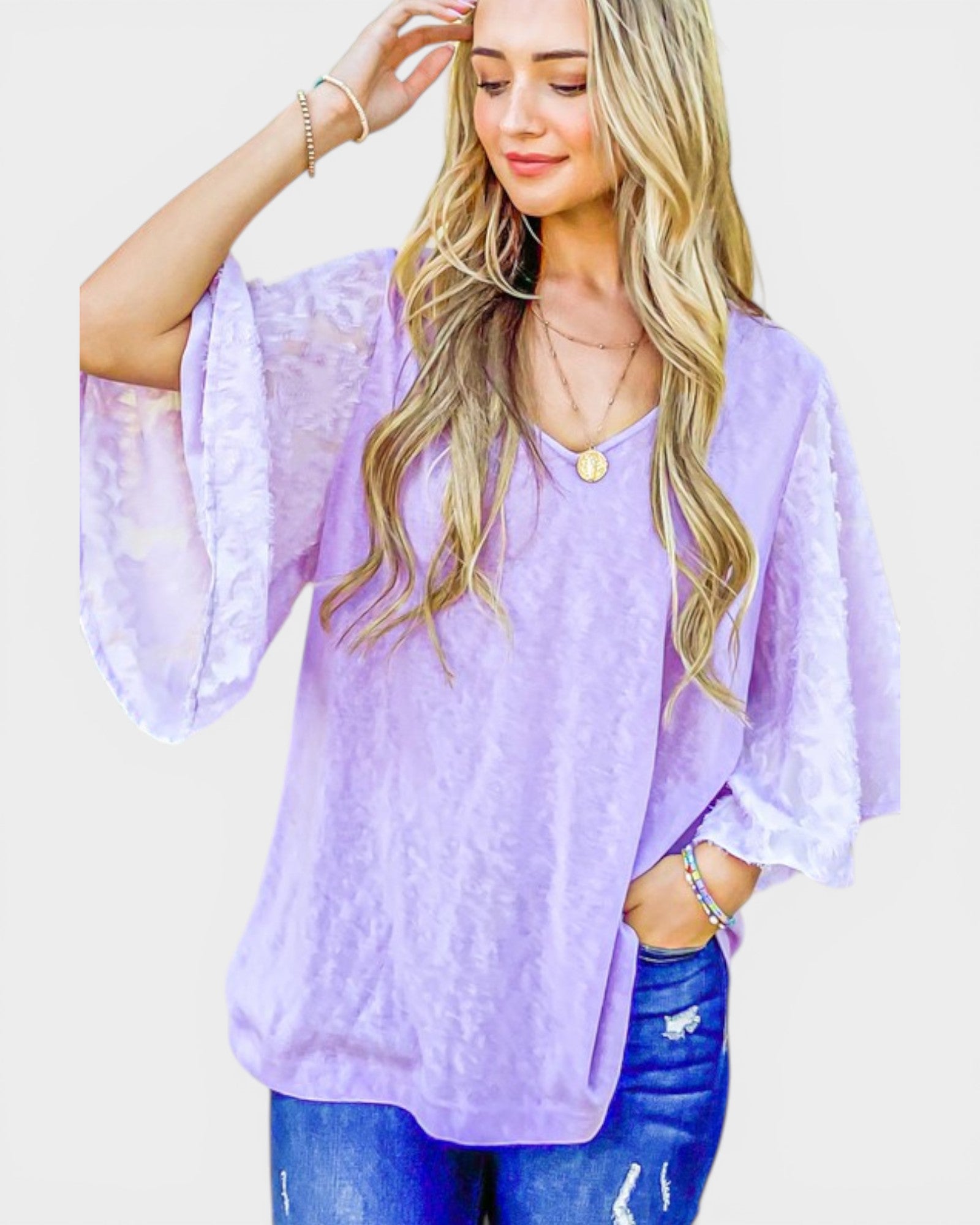 Woman wearing a light purple blouse with lace sleeves on a white background