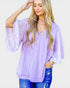Woman wearing a light purple blouse with lace sleeves on a white background