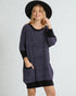 Woman wearing a dark blue knitted sweater with black cuffs and a black hat on a white background