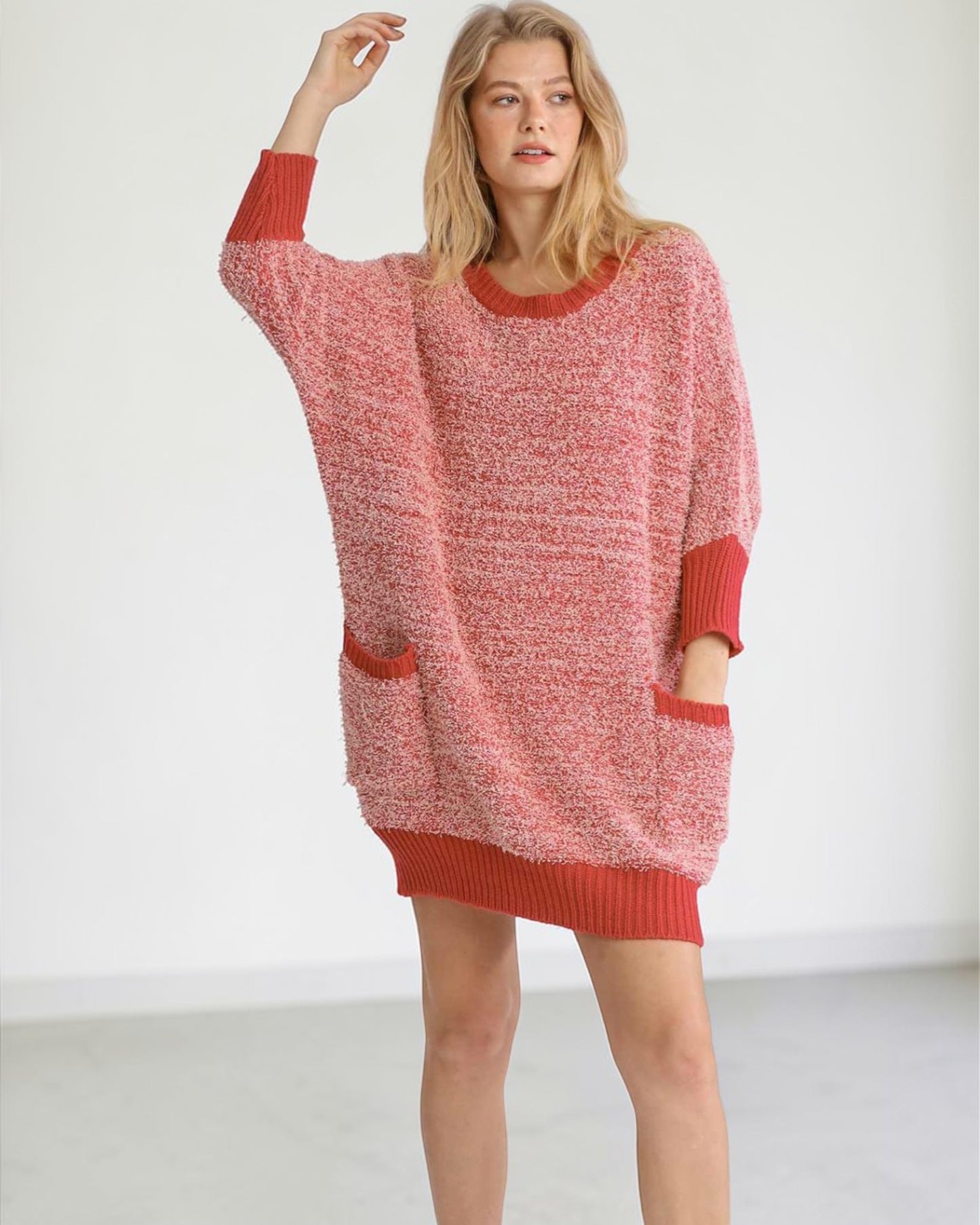 Woman wearing a red knitted dress against a white background