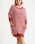 Woman wearing a pink knitted dress with red trim on a white background