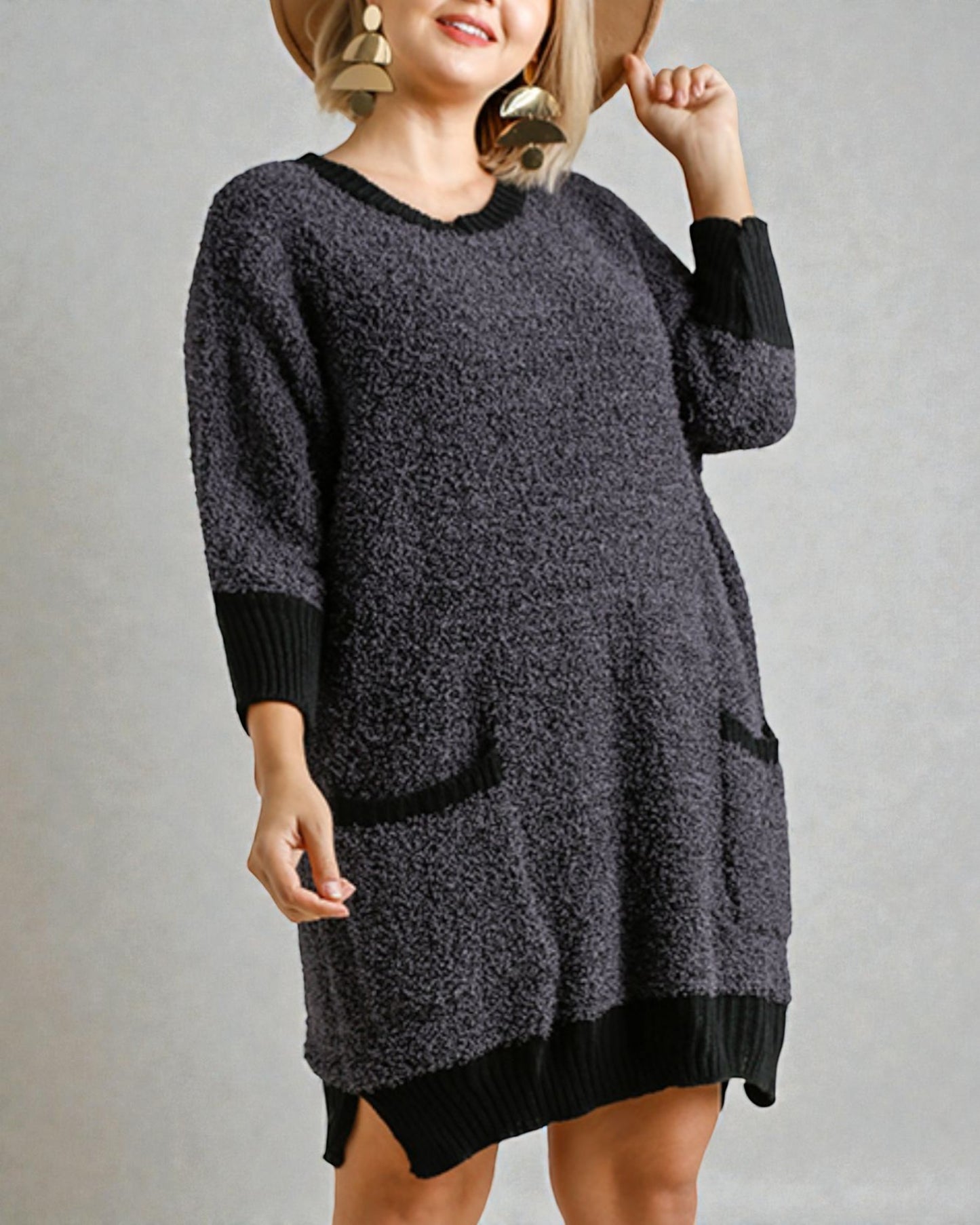 Person wearing a gray sweater dress with black accents on a plain background