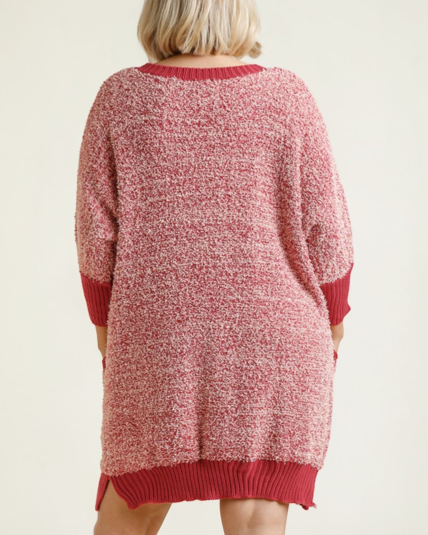 Red knitted sweater dress worn by a person on a beige background