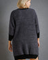Person wearing a textured gray cardigan against a gray background