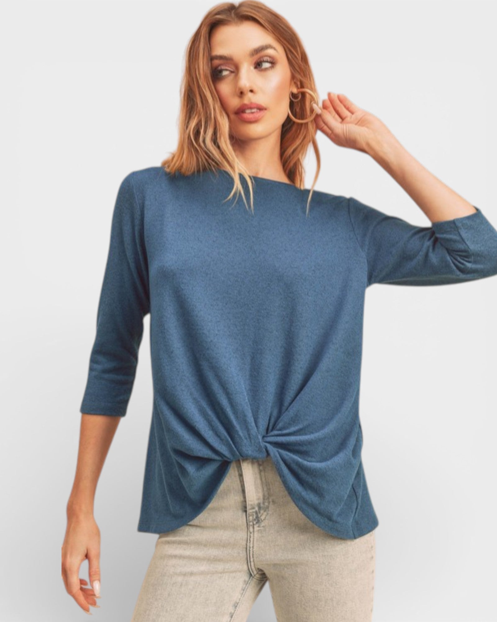 Woman wearing a blue top with a knot detail on a white background