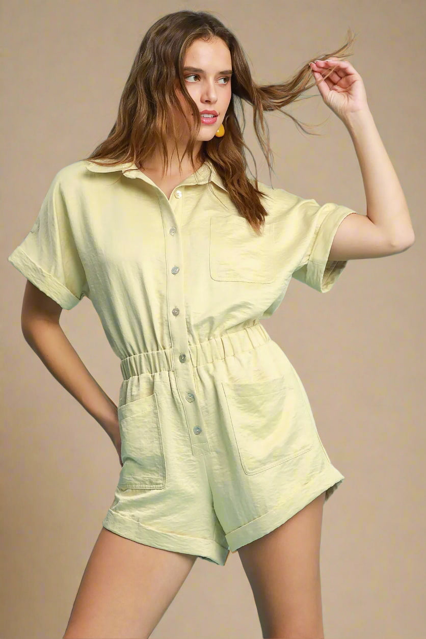 Woman wearing a light green romper against a beige background