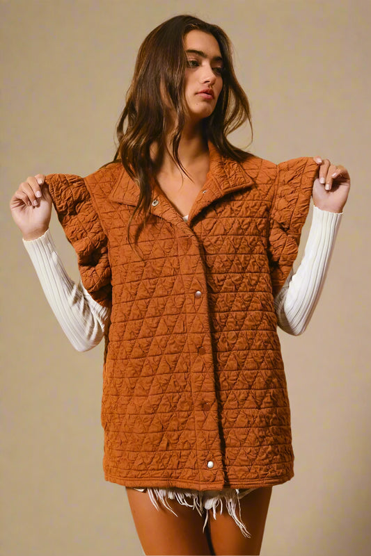 Woman wearing a brown quilted vest against a beige background