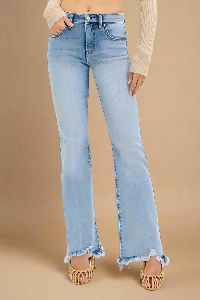Light blue flared jeans worn by a person on a beige background