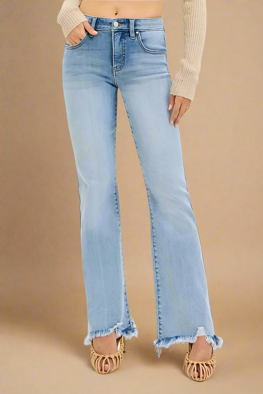 Light blue flared jeans worn by a person on a beige background