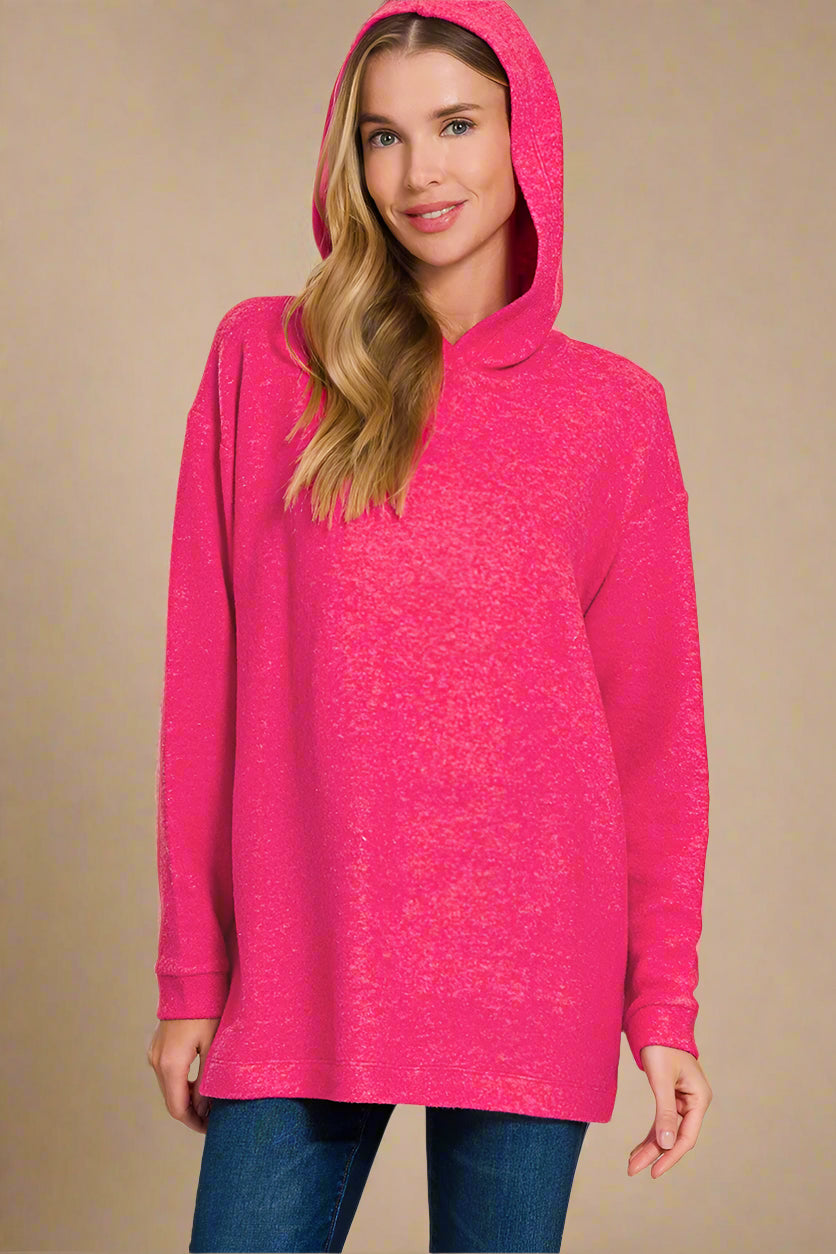 Woman wearing a hot pink hoodie on a beige background