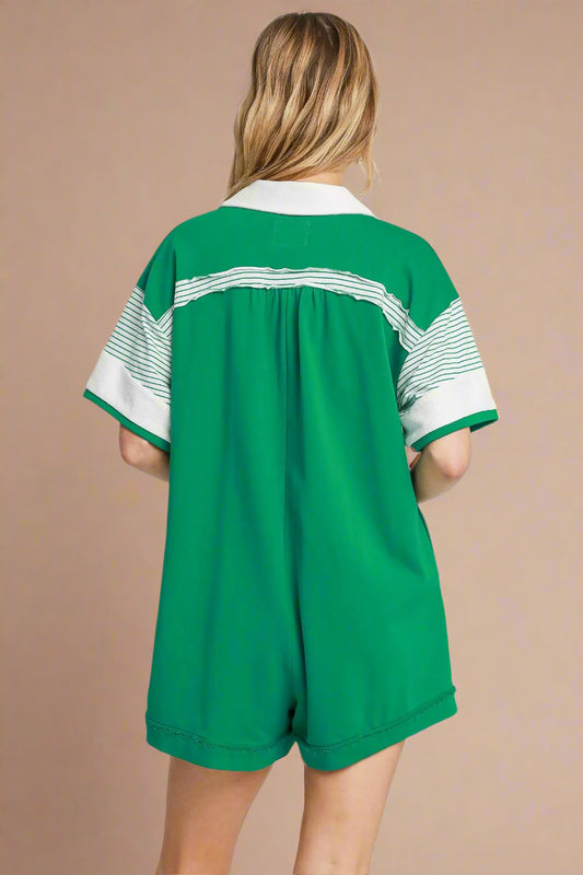 Green romper with white accents on a beige background