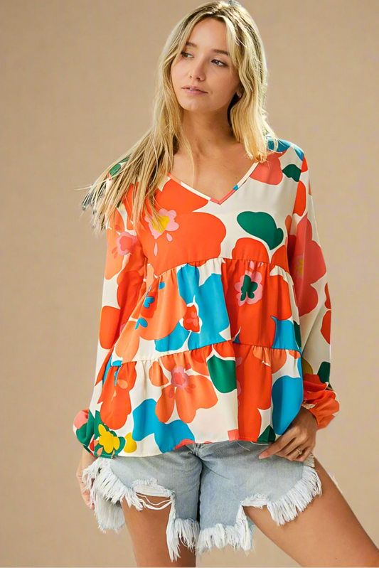 Woman wearing a colorful floral blouse and denim shorts