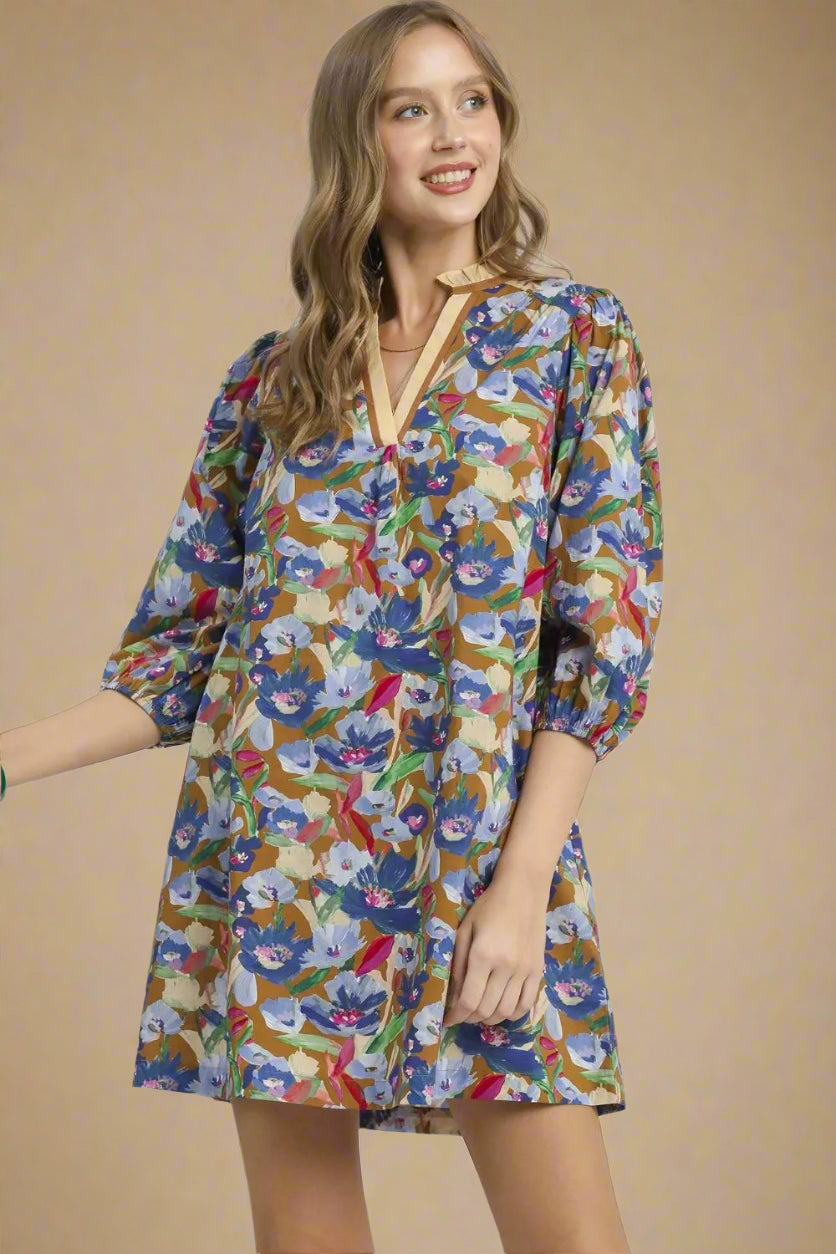 Woman wearing a colorful floral dress on a beige background